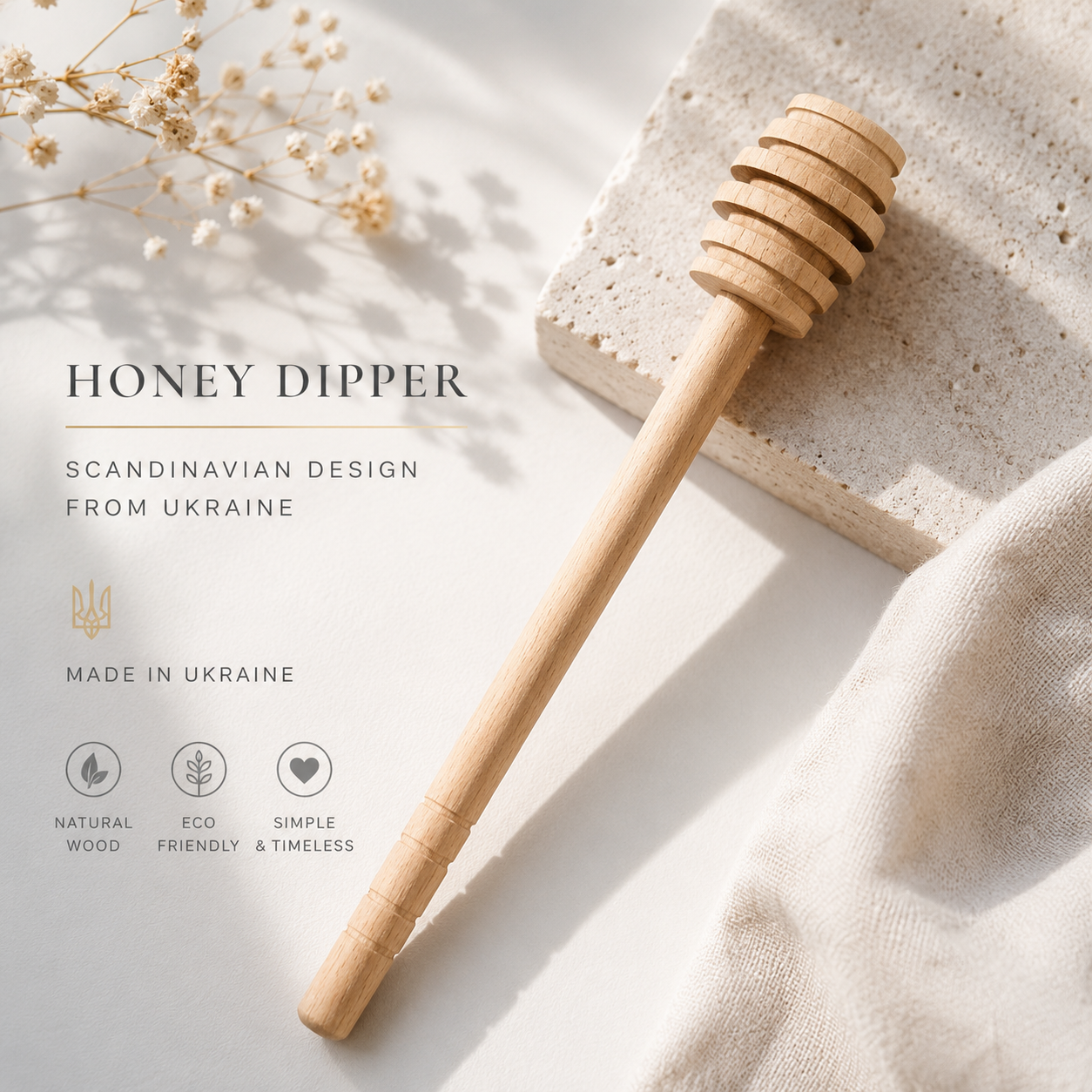 Wooden honey dipper on a light surface with text about its design and origin.